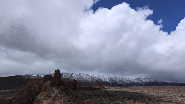 Snow covered Teide volcano landscape after storm Therese in Tenerife Canary Islands, dramatic clouds, volcanic terrain and winter conditions in subtropical island