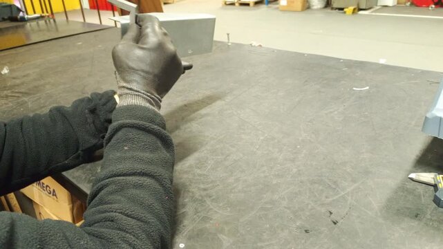 Metalworker checking the bending angle of a metal part with a square ruler."