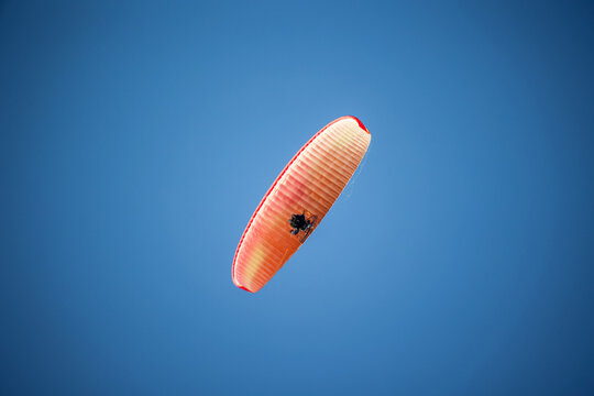 Ein Paragleiter mit Motorantrieb am Himmel.
