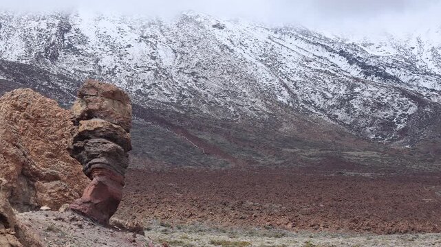 Snow covered Teide volcano landscape after storm Therese in Tenerife Canary Islands, dramatic clouds, volcanic terrain and winter conditions in subtropical island
