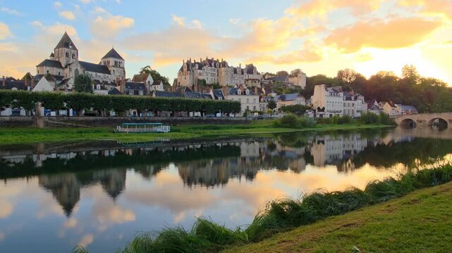 Beautiful sunset in the Loire Valley of France. Slow panning motion. Cathedral and chateau of Saint Aignan with reflections in the Cher River.