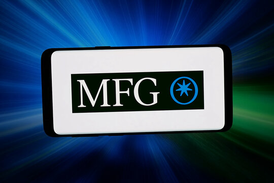 Stuttgart, Germany - 03-18-2026: In this photo illustration, the logo of company Magellan Financial Group (MFG) is displayed on a smartphone in front of abstract background on computer screen.