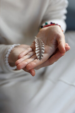 Female Hands Holding Feather, Feminine Energy and inner peace concept