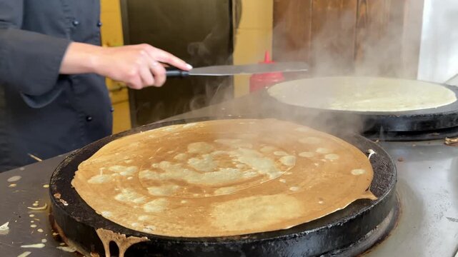 Buttering hot freshly baked crepes. Cooking pancakes at home. Delicious food, breakfast