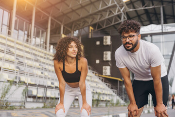 Obraz premium Athletes recovering from jogging, exercising together in an urban sports arena for health and wellness. Healthy lifestyle