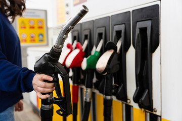 Hand gripping fuel pump nozzle while filling car tank. © Rabizo Anatolii