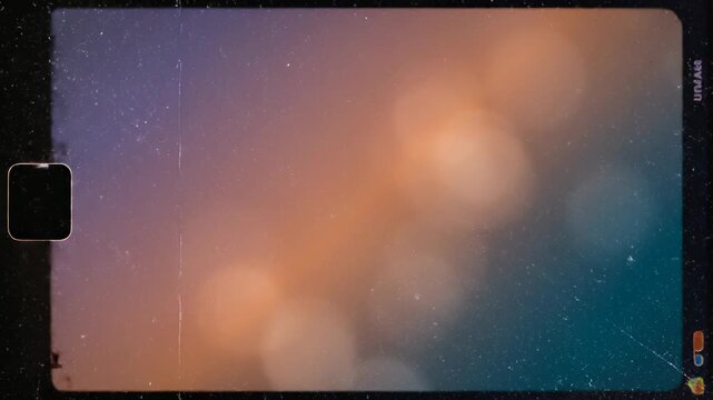 Vintage film frame video with heavy scratches dust and grain effects moving over a soft warm bokeh background. Nostalgic retro cinematic atmosphere