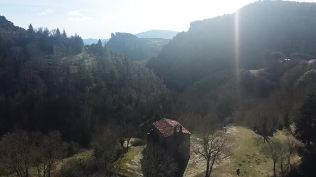 Panoramic drone shot from Rupit towards the Ermita de Santa Magdalena and the stunning mountain valley