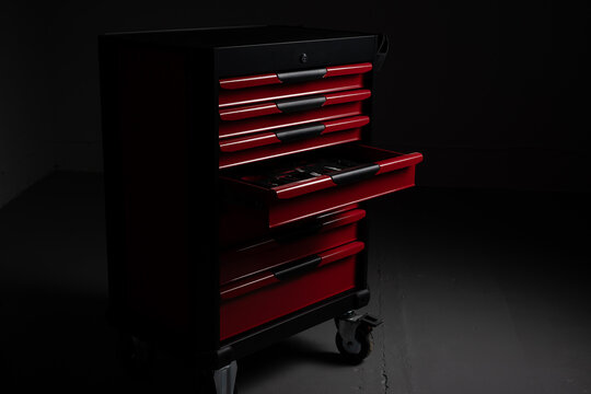 Red rolling tool chest with open drawer on workshop