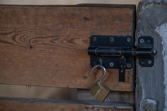 Padlock on wooden door latch, security and protection concept