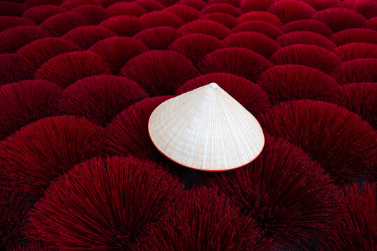 Vietnamese hat with red incense sticks