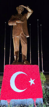 Bronze statue of Mustafa Kemal Ataturk with Turkish flag at night