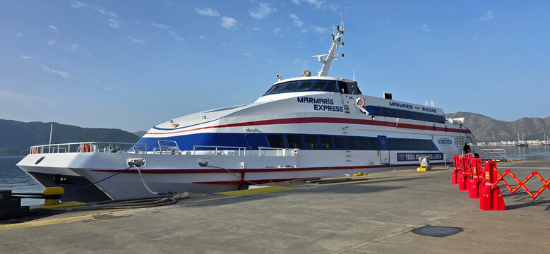 Fast ferry boat Miramar Express docked at harbor with scenic mountains