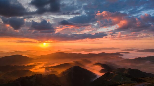 Sunlight illuminating foggy mountain ridges at sunrise