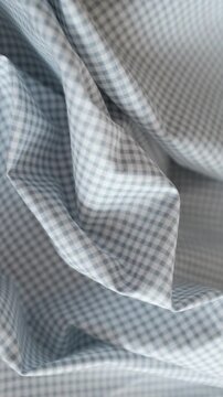 Close-up of soft blue and white gingham fabric texture with gentle folds and ripples. Classic checkered pattern textile background for fashion, home decor, and rustic themes.