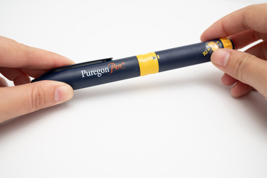 Hands holding Puregon Pen for fertility treatment injection