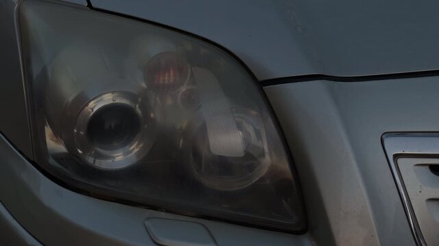 Nighttime transition shot depicting warm headlights shining through evening suburban landscape with cinematic lighting