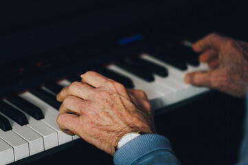 Music therapy for seniors: elderly man playing piano to improve fine motor skills and cognitive health © Anna Kondratiuk