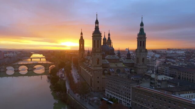 Aerial View Capturing Sunset Glow Illuminating Cathedral Domes And Tranquil River Reflections. Zaragoza. Spain 