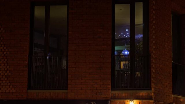 Lit window scene. Nighttime studio with lighting. Warm ambiance reflected through illuminated windows