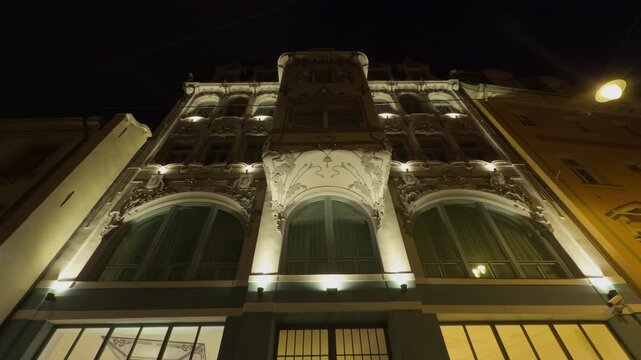 Ancient structure lit. Nighttime lighting highlights elaborate and detailed design of historic building facade