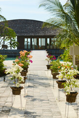 Fototapeta premium Classic Maldives island landscape on a sunny day, coastal luxury resort buildings, azure water, white sand, palm trees on the shore