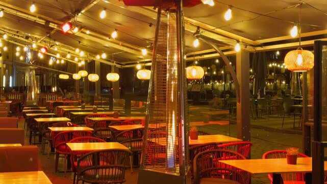 Serene city patio bathed in gentle lighting. Silent streetside cafe with warm glowing outdoor furniture