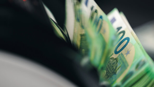 Banknotes stacked in money counting machine tray. Profit and wealth concept.
