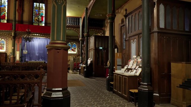 Gothic church interior with chandeliers chairs and visitor Paris France