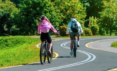 Naklejka premium Cyclists ride on the bike path in the city Park