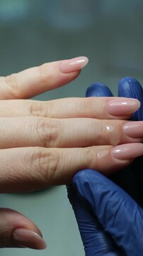 Careful hand care: pushing back cuticles and applying healing polish to strengthen brittle nails. High quality 4k footage
