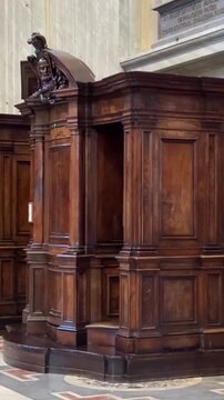 St Peters Basilica confessionals stand as intimate booths pilgrims quietly confess pray reflect while visitors admire ornate artworks sacred marble interiors. Vatican City, Italy 11.30.2025