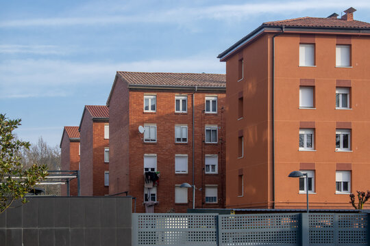 Hilera de edificios residenciales de ladrillo rojo bajo un cielo azul en Burgos, Espa&ntilde;a