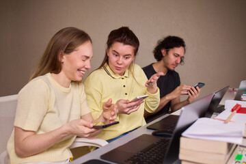 Fototapeta premium Individuals engaged in informal discussion about mobile device features. Casual indoor gathering where friends analyze smartphone screens and share opinions warmly