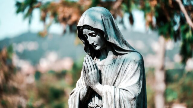 Marble statue praying in outdoor garden with blurred palms