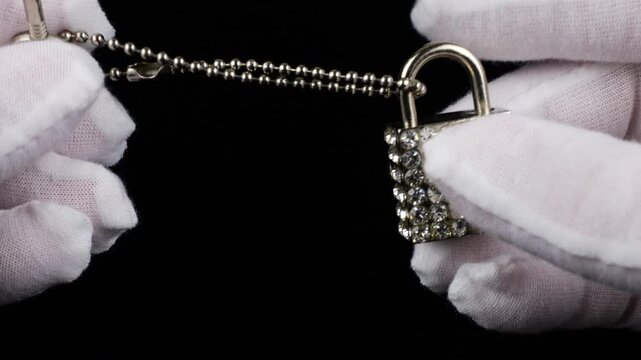 This elegant keychain for a bag is designed as a decorative lock with a key. The entire piece is richly decorated with sparkling rhinestones that catch the light.