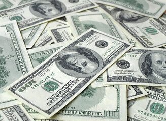 Fototapeta premium A stack of $100 bills. A lot of money. Scattered freely on the surface.