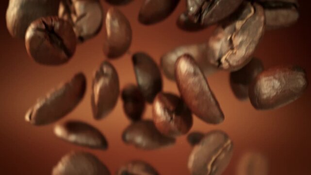 Super Slow Motion Macro of Coffee Beans Falling on Brown Cinematic Background at 1000fps.