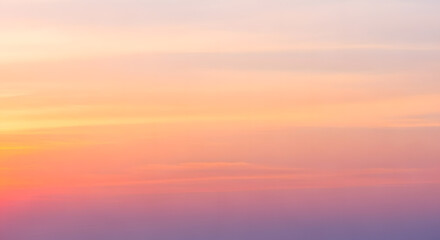 Fototapeta premium A serene sky with soft pastel colors transitioning from warm orange and pink to cool purple, perfect for a seamless background