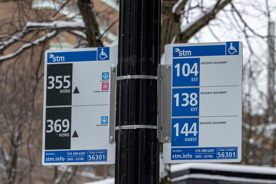 MONTREAL, CANADA, 25 December 2025 : Public transit bus stop sign winter trees snow STM Canada