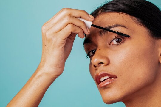 Woman applying mascara close-up.