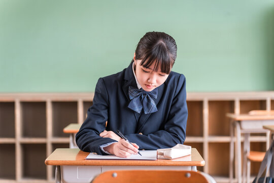Middle school and high school girls taking tests in school classrooms or cram school classes.