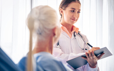 Professional Medical Doctor diagnosing and giving advice to the elderly patient at hospital. Healthcare homecare concept