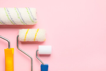 Obraz premium Different paint rollers on pink background