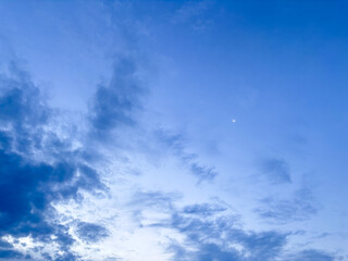 Obraz premium Blue sky with textured clouds and crescent moon in peaceful atmosphere