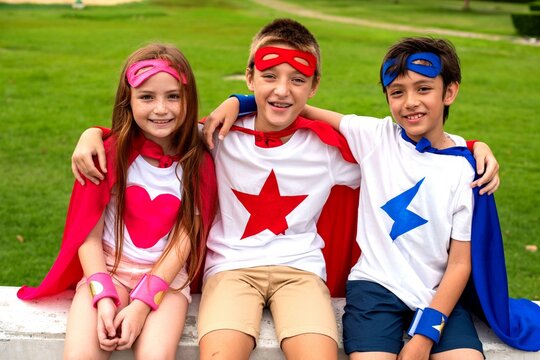 Children in superhero costumes smiling