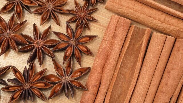 Detailed macro flat lay of star anise and cinnamon sticks on a wooden board. Clean organic spice textures for culinary and traditional medicine concepts.