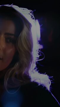 Vertical video: Female singer leaning into mic and singing for music, lamp making rim flare