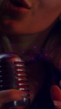 Vertical video: Singer pulling mic close, shifting soft to loud for music, purple glow around mic