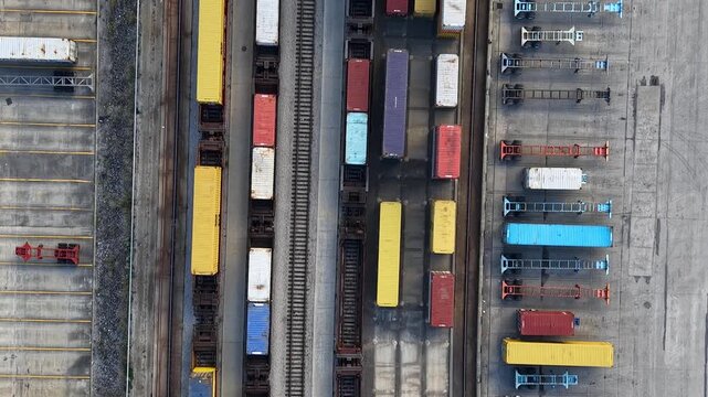 Gantry crane moving cargo containers at a industrial railway terminal